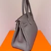 Authentique et neuf, le sac Birkin 30 Hermès couleur Étain doré avec finitions dorées, en cuir Clémence.